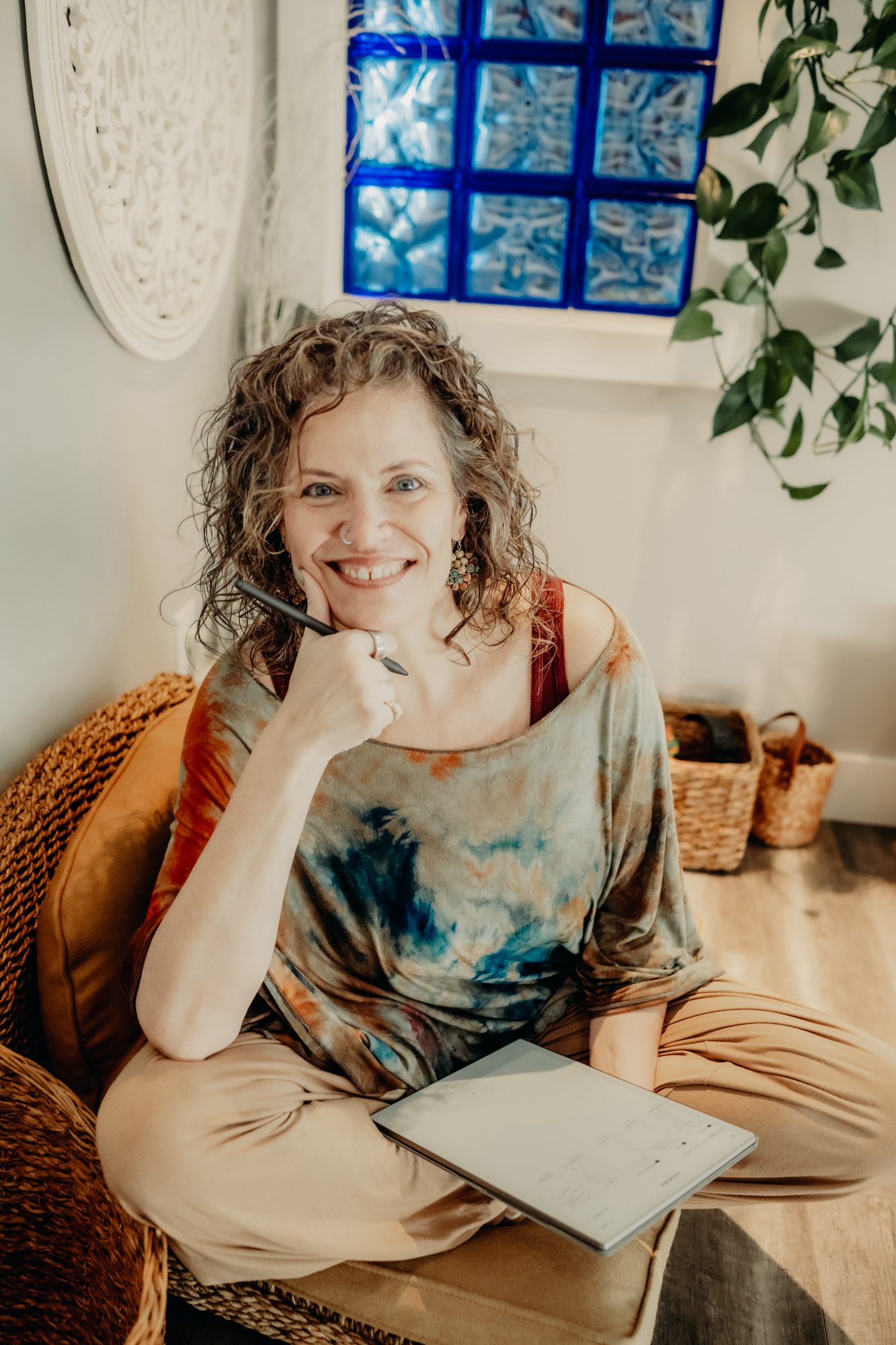Katharine Zink seated warmly, smiling with notebook