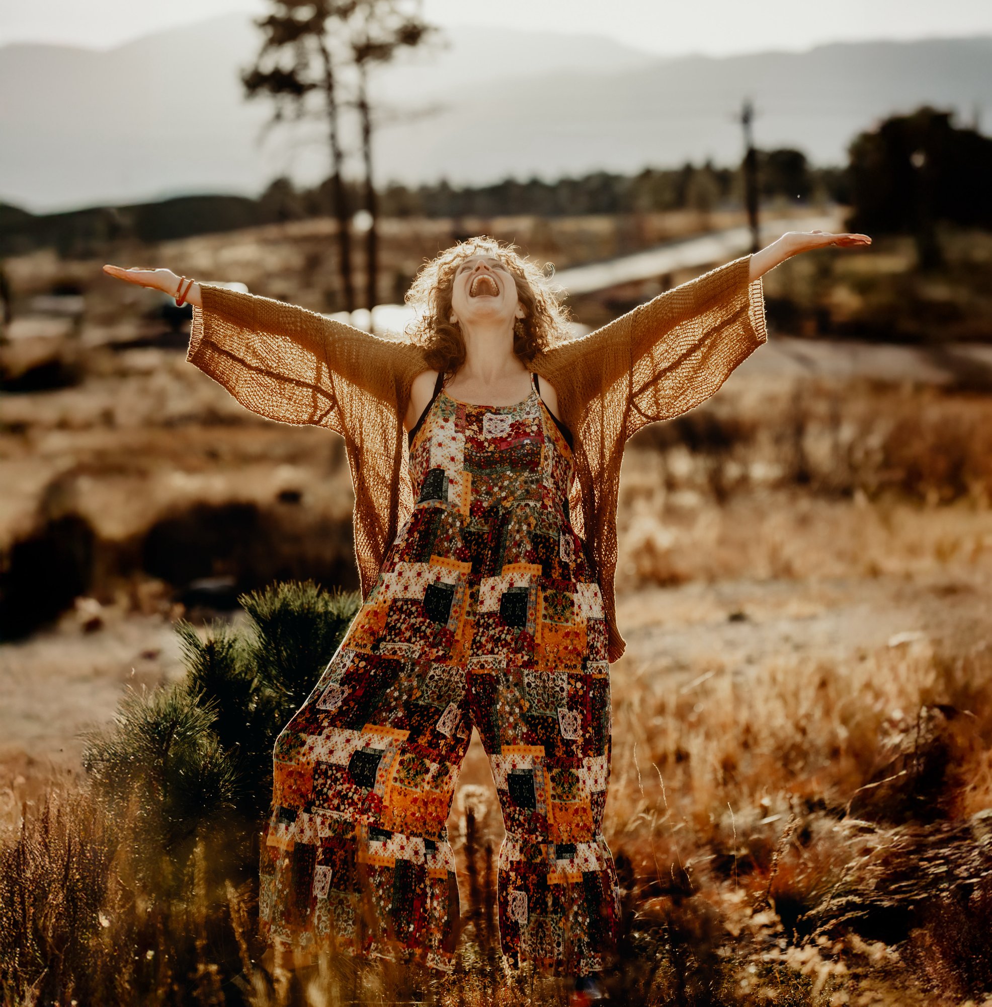 Katharine Zink with arms raised, golden Colorado field