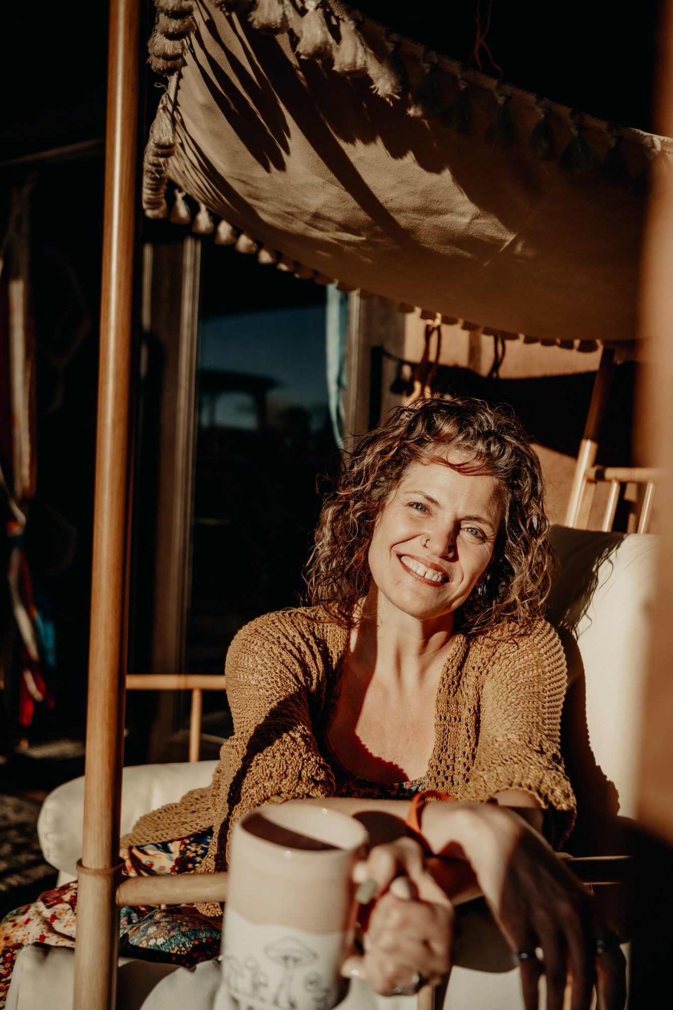 Katharine Zink seated warmly in a canopy setting